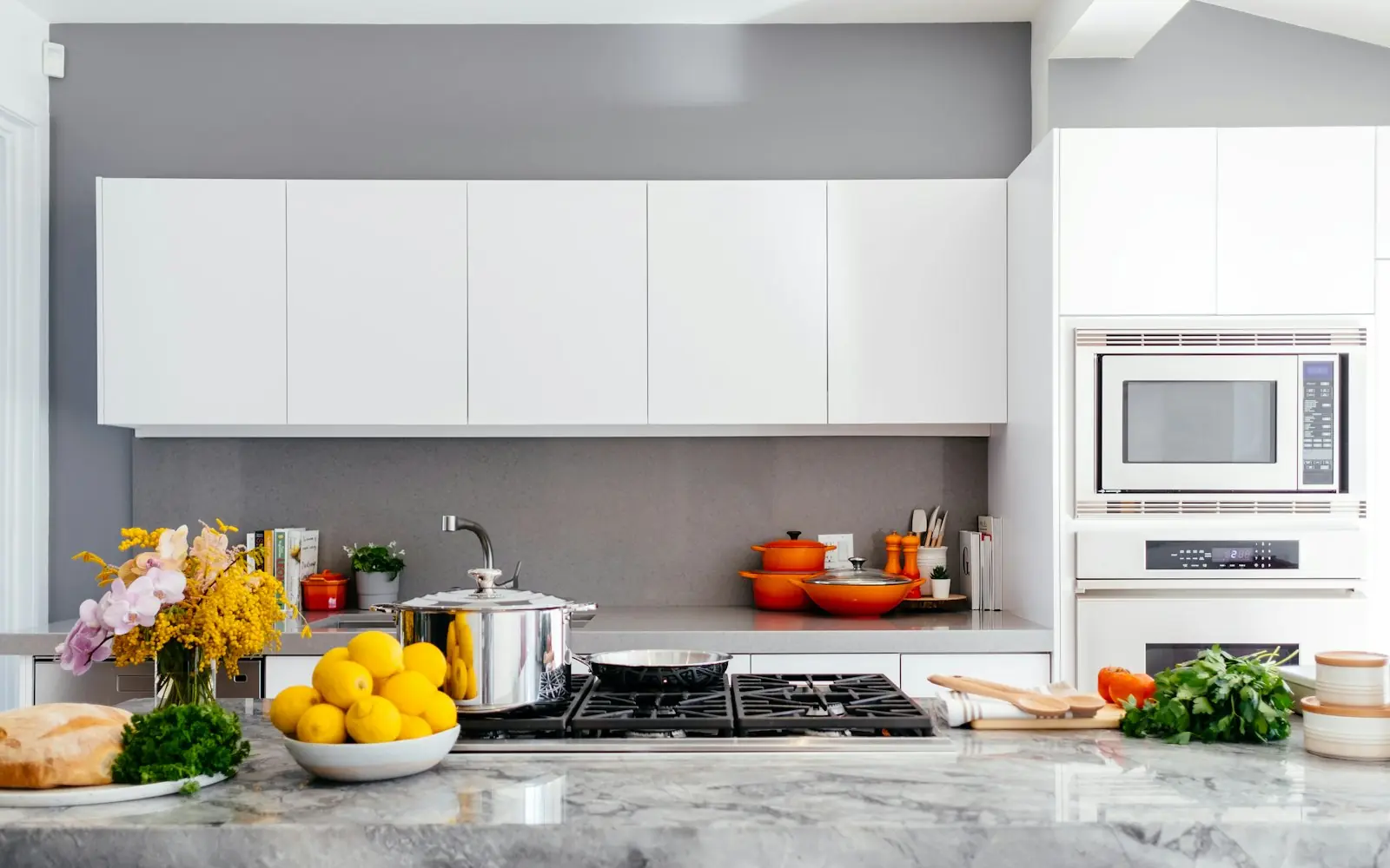 White modern kitchen with a clean backsplash and cooktop